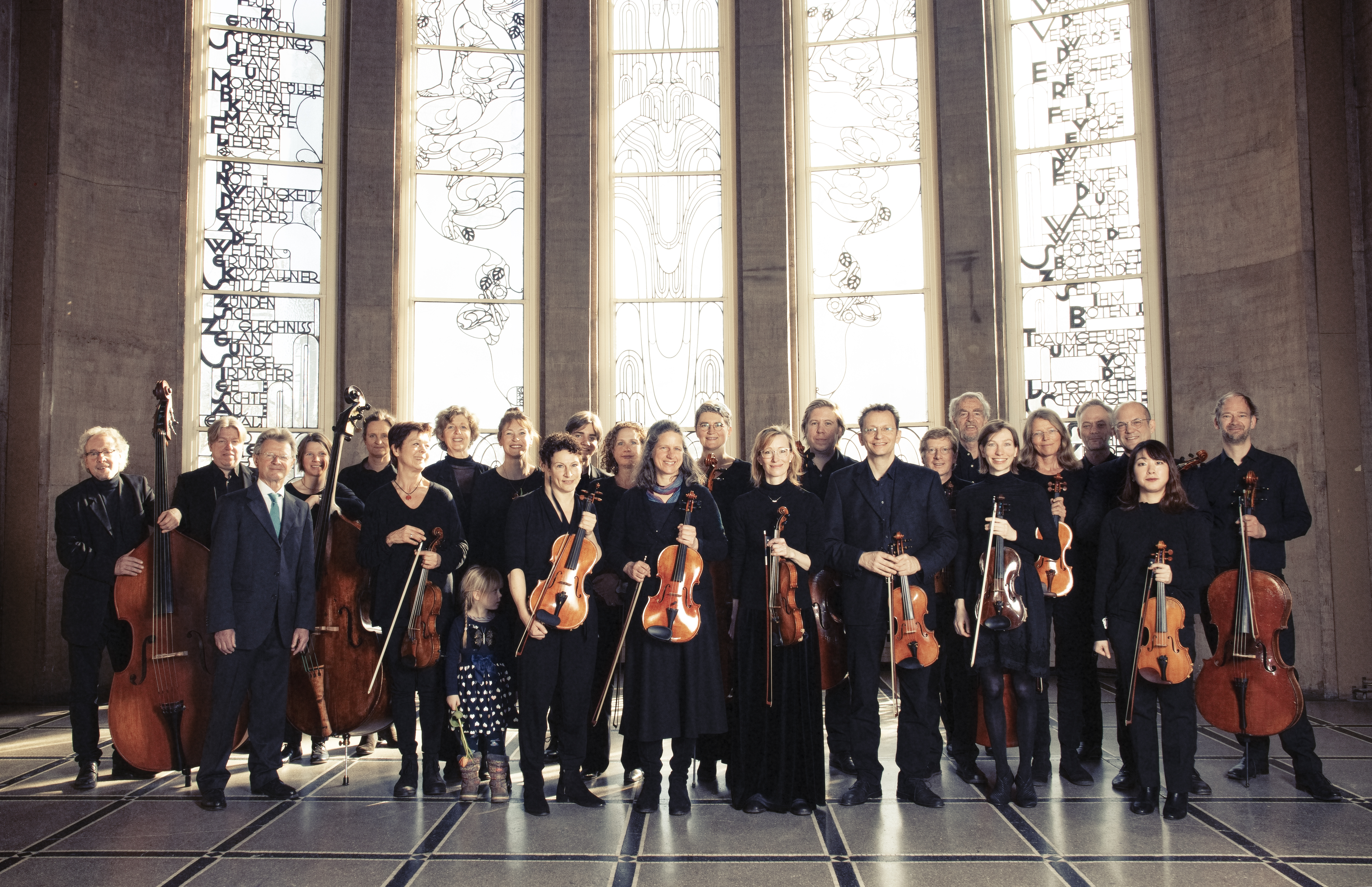 Orchesterfoto vor verzierten Fenstern