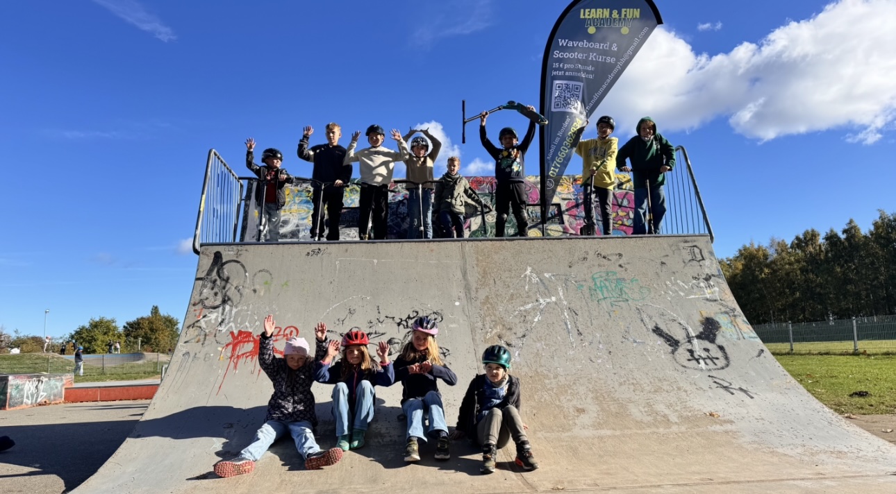 Gruppenfoto nach einem erfolgreichen Waveboard- und Scooterkurs - Kinder und Jugendliche gemeinsam auf der Skateanlage nach dem Training.