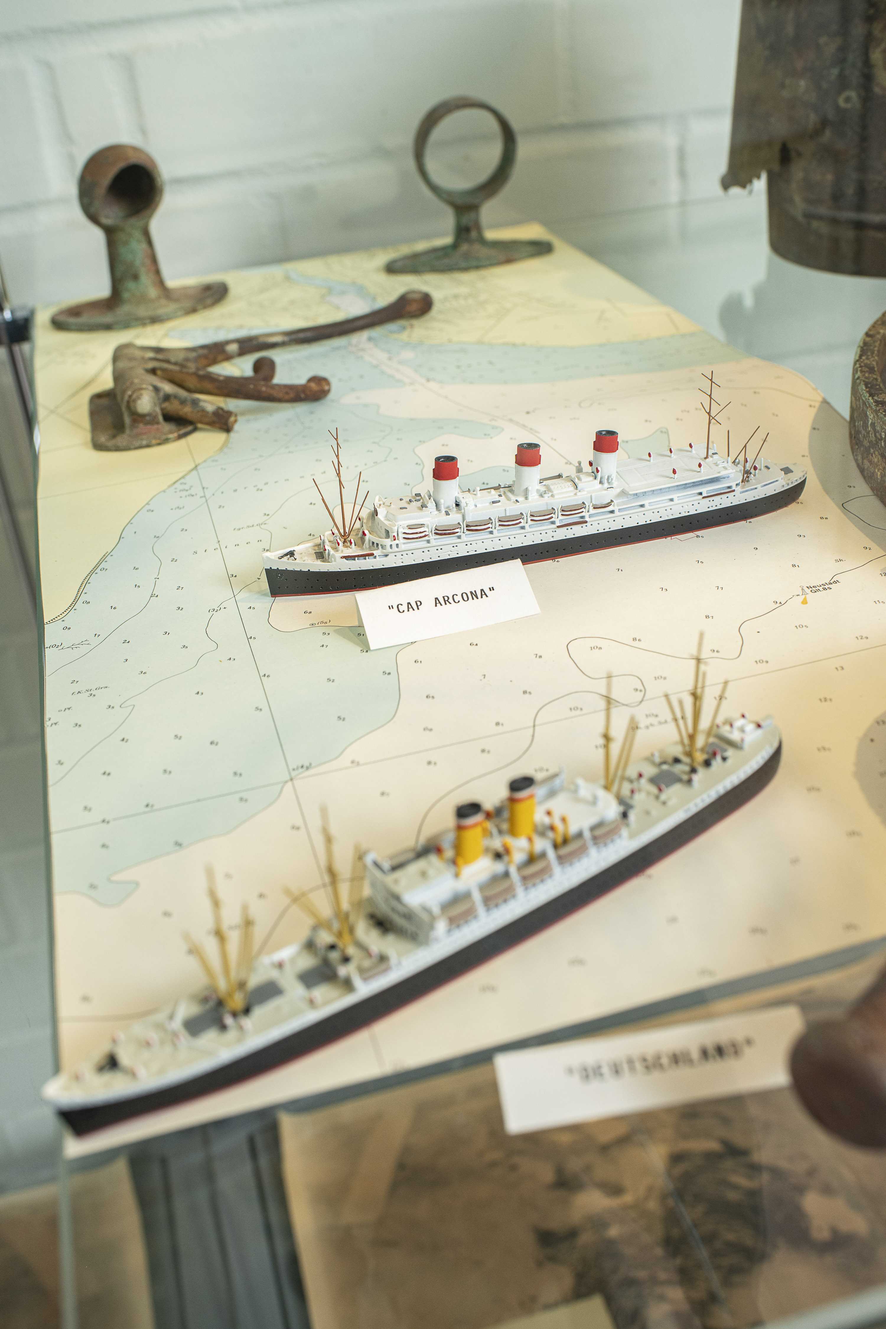 Auf einer Seekarte sind zwei Schiffe abgebildet, darunter das Passagierschiff Cap Arcona. Der Name Cap Arcona steht stellvertretend für die Ereignisse am 3. Mai 1945.