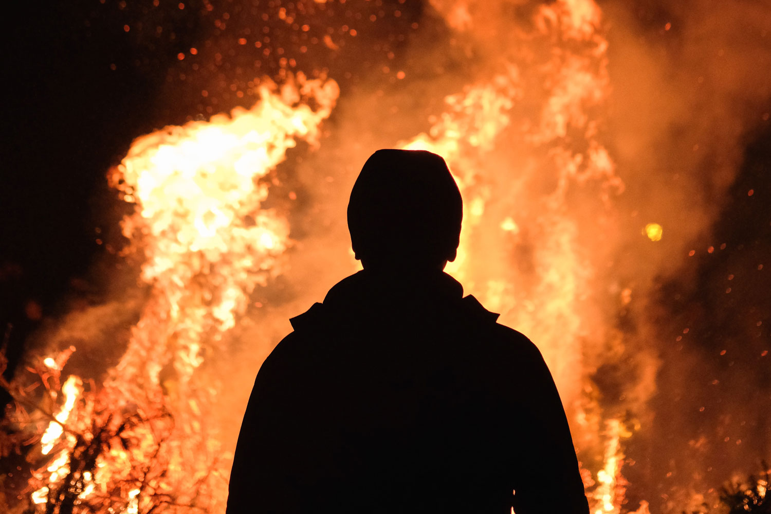 Silhouette vor loderndem Feuer